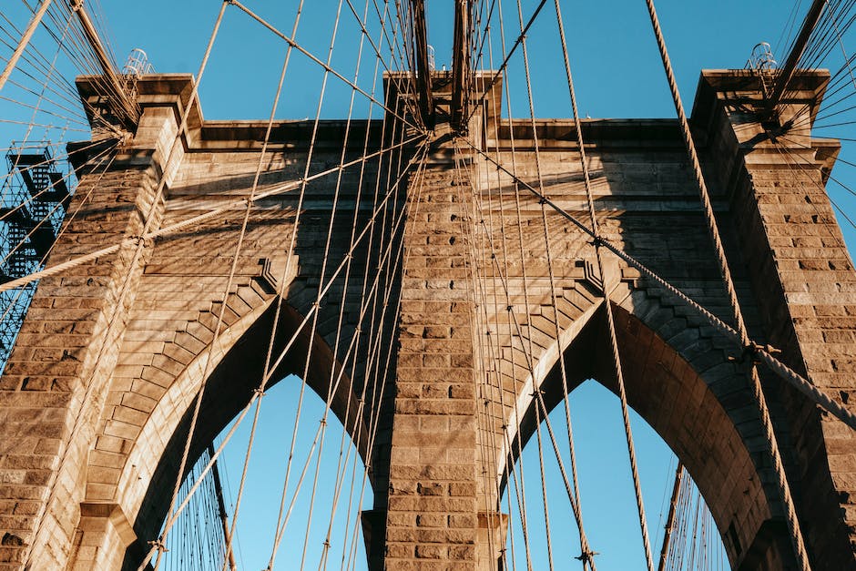 Low angle of famous Brooklyn brick arches with ropes on top of bridge in metropolis