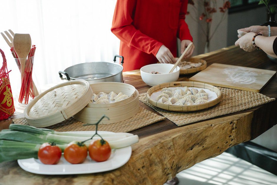 Unrecognizable women cooking Asian dumplings with meat and veggies in kitchen