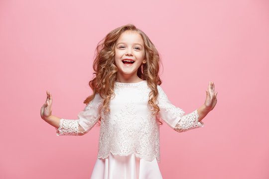 The beautiful little girl in dress standing and posing over white background