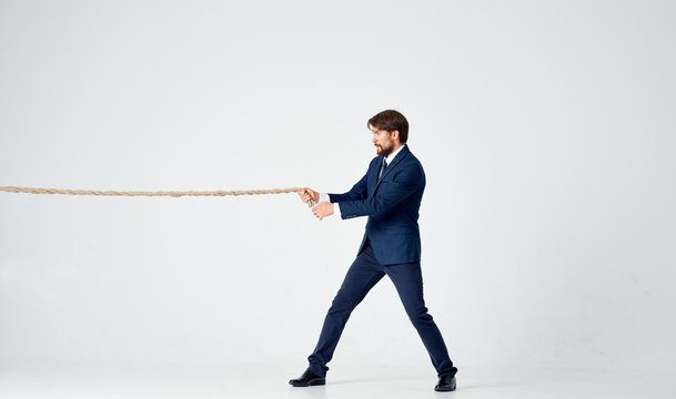 business man pulls the rope on a light background